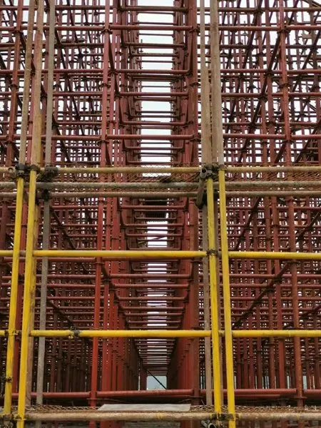 Corridor view through painted shoring with yellow ledgers marking each lift
